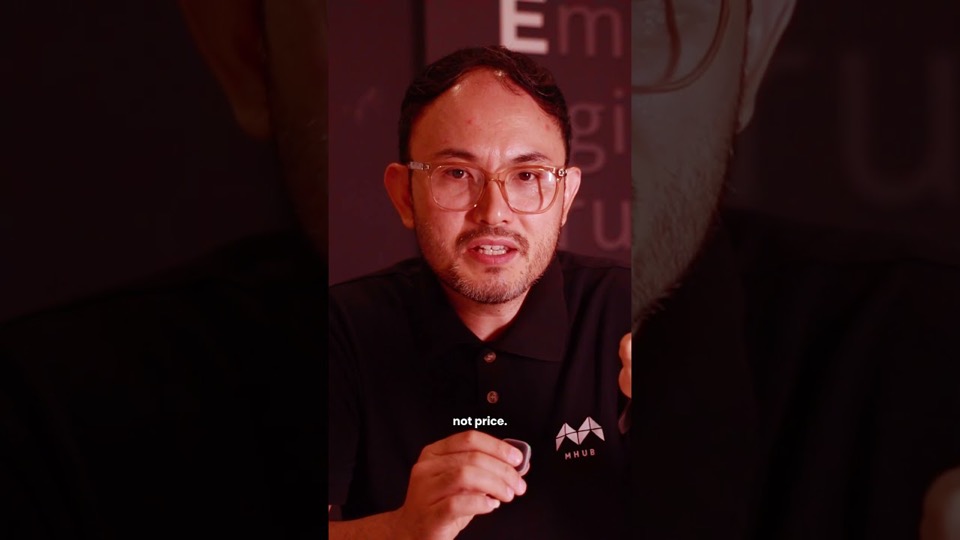 A presenter in an MHub polo shirt talking to camera under red lighting, with the on-screen caption "not price".